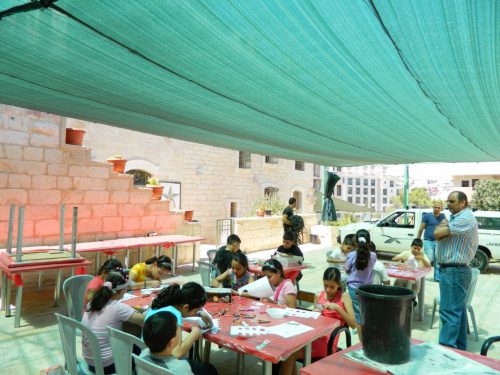 Some of our summer campers doing arts and crafts under our new shade canopy